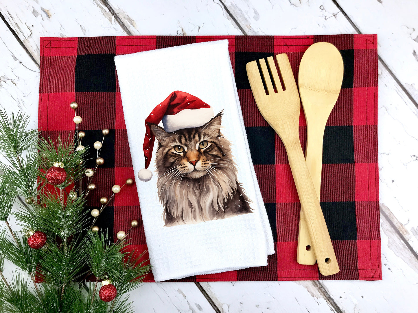 Maine Coon cat wearing a santa hat on a tea towel