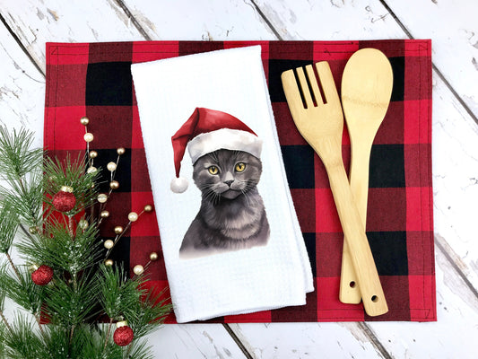 Russian Blue cat wearing a santa hat on a kitchen tea towel as a gift